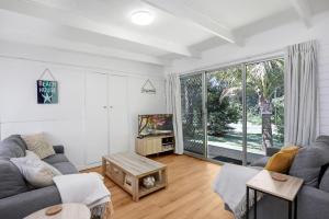 a living room with a couch and a tv at Billa Bungalow - 16 Billa Street in Point Lookout
