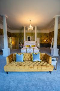 a living room with a couch in front of a bed at Broome Park Hotel in Canterbury