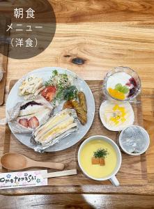 una mesa de madera con platos de comida. en 海が見えるゲストハウス　浜んちゅ, en Yamato