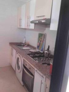 een keuken met een fornuis en een wasmachine bij Appartement en location in Fnidek