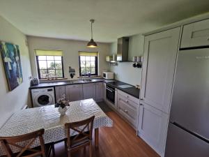 a kitchen with a table and a dining room at Ban Milis 1 in Fethard on Sea