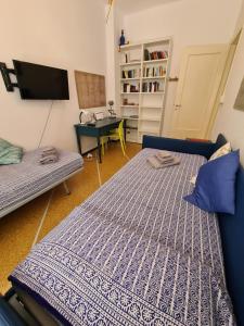 two beds in a room with a desk and a tv at Noah Andrea by PortofinoVacanze in Santa Margherita Ligure