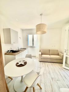 een witte keuken en een woonkamer met een tafel en stoelen bij Bilocale Vista Mare in Marettimo