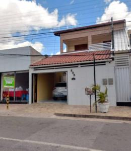 ein weißes Gebäude mit einem davor geparkten Auto in der Unterkunft Apto Temporada in Campina Grande