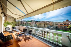 a balcony with chairs and a view of the city at Rivalta Hotel - Alfieri Collezione in Florence