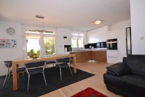 een keuken en woonkamer met een houten tafel en stoelen bij Villa Magalia in Bol