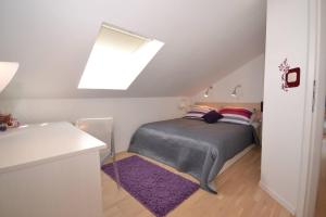 een slaapkamer met een bed en een dakraam bij Villa Magalia in Bol +13 foto's