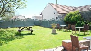 a yard with a picnic table and chairs and a fence at The Old Rectory - Brean in Brean