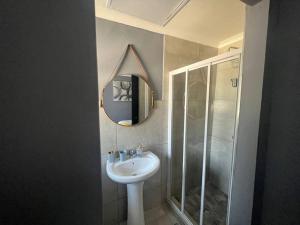 La salle de bains est pourvue d'un lavabo, d'une douche et d'un miroir. dans l'établissement Ubuntu Lifestyle Estate, à Krugersdorp