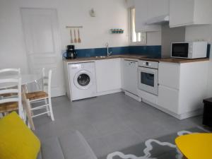 een keuken met een wasmachine en een magnetron bij T2 charmant bord de mer Pornichet avec terrasse in Pornichet