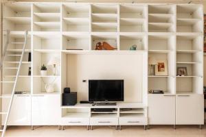 sala de estar con estanterías blancas y TV en Pirelli - Flexyrent WiFi - A.C., en Milán
