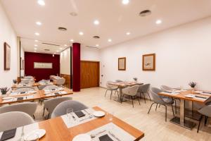a dining room with wooden tables and chairs at Catalonia Gran Hotel Verdi in Sabadell +31 photos
