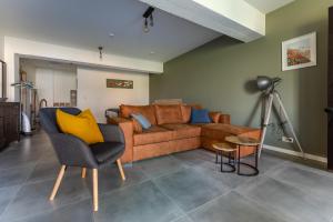 ein Wohnzimmer mit einem braunen Sofa und gelben Kissen in der Unterkunft De Hoog Velden 11 in Neerpelt