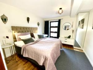 - une chambre avec un grand lit et un miroir dans l'établissement Apartment Aekta Studio 4 Gothenburg, à Göteborg