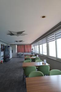 ein Klassenzimmer mit Tischen, Stühlen und Fenstern in der Unterkunft DEMİR OTEL RESTAURANT in Hamitler