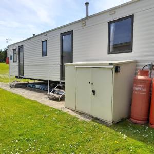 a mobile home with a garage in front of it at Yarborough View 1 Whitecliff Bay Bembridge Isle of Wight in Bembridge