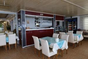 a restaurant with tables and chairs and a bar at DEMİR OTEL RESTAURANT in Hamitler