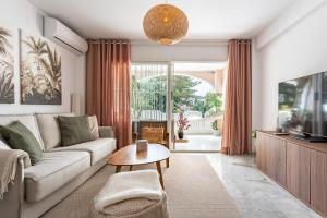 un salon avec un canapé et une télévision dans l'établissement Casa Medellin Beachfront oasis with pool, à Benalmádena