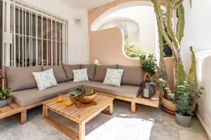 un patio avec un canapé et une table dans l'établissement Casa Medellin Beachfront oasis with pool, à Benalmádena