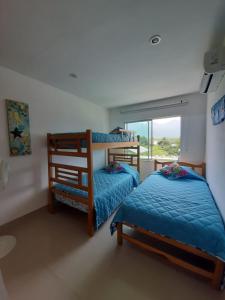 two bunk beds in a room with a window at Bello Horizonte * Unido Al Mar in Santa Marta