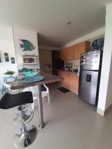 a kitchen with a table and a stainless steel refrigerator at Bello Horizonte * Unido Al Mar in Santa Marta