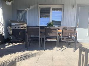 einen Grill und einen Tisch mit Stühlen auf einer Terrasse in der Unterkunft Ferienwohnung Zur Sperrmauer in Edersee