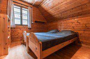 a bedroom with a bed in a wooden cabin at Mala koča Wooden Cabin in Goreljek