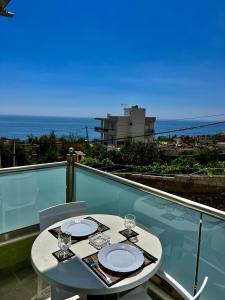 una mesa en un balcón con vistas al océano en Oscar’s Apartments Drymades en Dhërmi