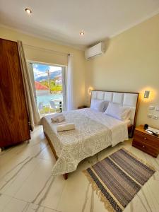 een slaapkamer met een groot bed en een groot raam bij Oscar’s Apartments Drymades in Dhërmi