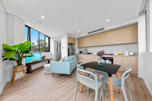 een keuken en een woonkamer met een tafel en stoelen bij Elegant and Modern Style Apartments in Dulwich hill in Sydney