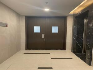 uma porta castanha num quarto com piso em azulejo em Compass One Building - Luxury Apartments em Ấp Phú Thọ