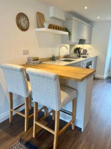 cocina con mesa de madera y 2 sillas en Wesley Cottage, en Middleham