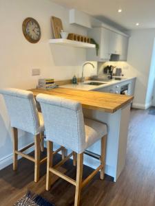 a kitchen with a wooden table and two chairs at Wesley Cottage in Middleham