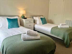 two beds in a room with towels on top of them at Wesley Cottage in Middleham