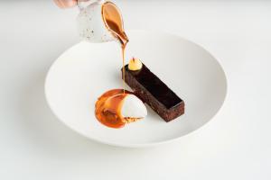 a piece of chocolate cake on a plate with a spoon at ibis Deira Creekside Dubai in Dubai