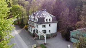 an aerial view of a large white house in the woods at Naturhotel Forsthaus in Annaberg-Buchholz