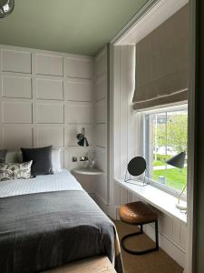 ein Schlafzimmer mit einem Bett, einem Fenster und einem Stuhl in der Unterkunft Rooms Above Sugar Boat in Helensburgh