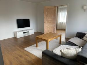 a living room with a couch and a table and a tv at Cozy apartment near TalTech and Elamus SPA in Tallinn