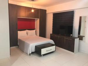 1 dormitorio con 1 cama y TV de pantalla plana en Suite Rio stay, en Río de Janeiro