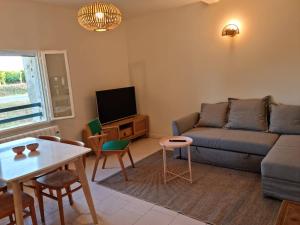 a living room with a couch and a table at Gîtes de l'Estagnol in Villeneuve-lès-Maguelonne
