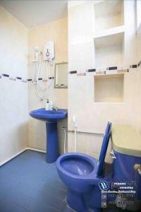 a bathroom with a blue toilet and a sink at Cozy 6BR Gurney GeorgeTown Homestay in Tanjung Bungah