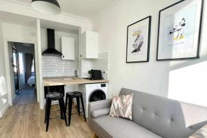 a living room with a couch and a kitchen at Yellowstone Ático luminoso y acogedor in Ferrol