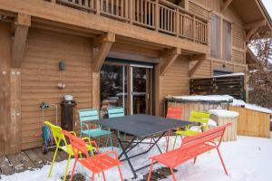 une table et des chaises dans la neige devant une maison dans l'établissement Apartment Marmottes Suisses, aux Gets