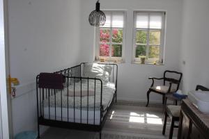 a baby crib in a room with a window at Pension Burgenring in Schlitz