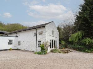 a white house with a gravel driveway at Nant Coed Barn in Abergele