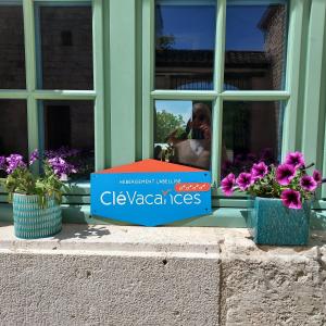 a sign in front of a window with flowers at MANOIR Le Moulinal47 - vue panoramique in Courbiac