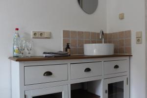 a kitchen with a white dresser with a sink at Pension Burgenring in Schlitz