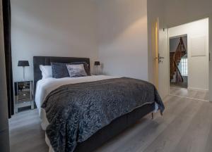 a bedroom with a large bed with a black blanket at EXECUTIVE DOUBLE ROOM WITH EN-SUITE in GUEST HOUSE RUE TREVIRES R3 in Luxembourg