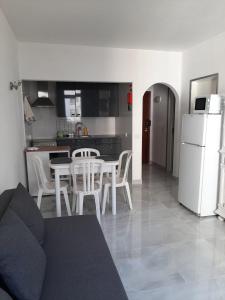 sala de estar y cocina con mesa y sillas en Casa da Praia, en Armação de Pêra