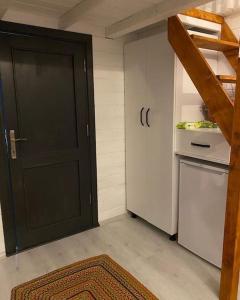 a kitchen with a black door and a refrigerator at Maşukiye pink house bungalow in Kartepe